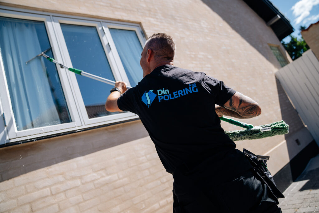 vinduespudser pudser med teleskopstang på et vindue